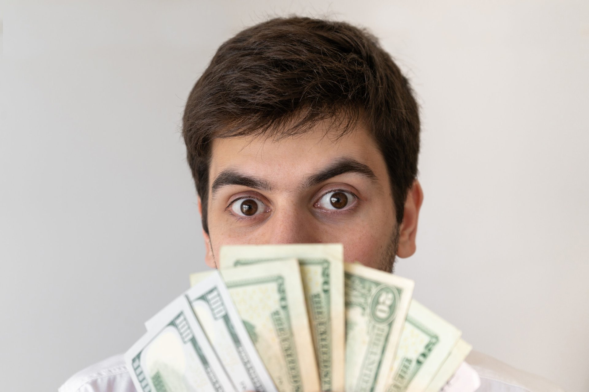 Man peaking behind cash